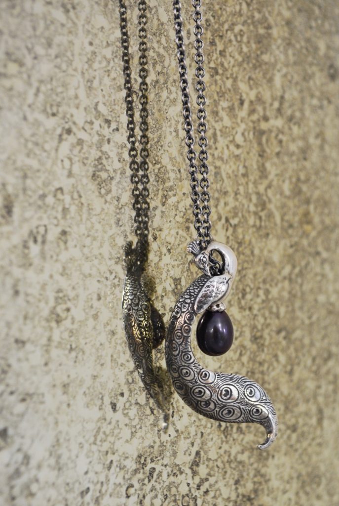 A beautiful silver Peacock Pendant swings on a Trollbeads Fantasy necklace