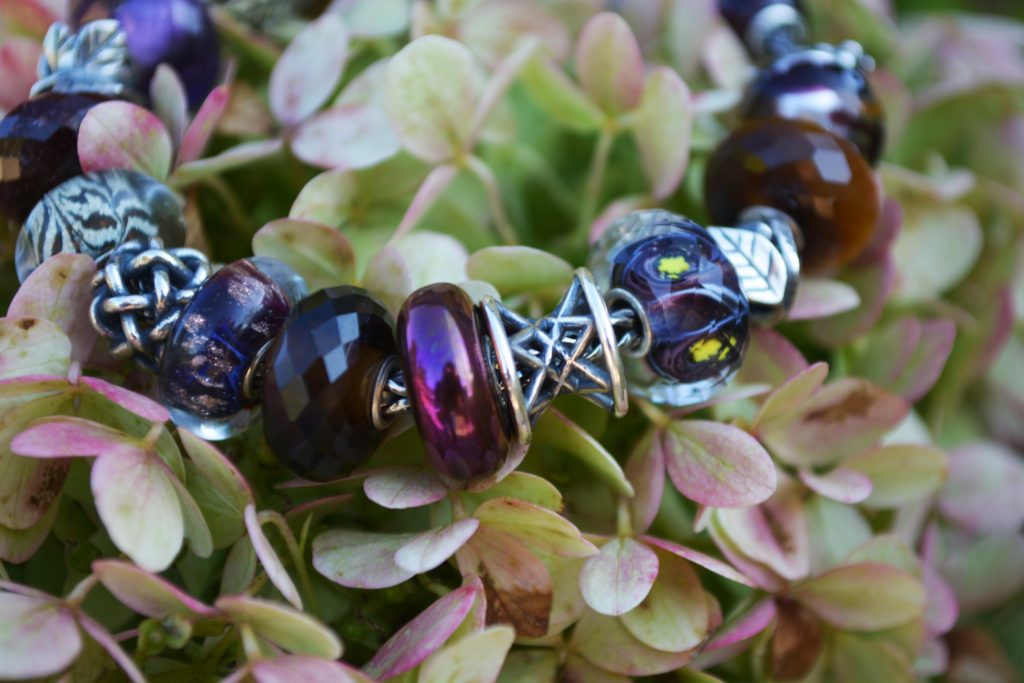 Trollbeads Akron Inspiration Image with deep purples and reds, highlighting the Hope Facet Bead