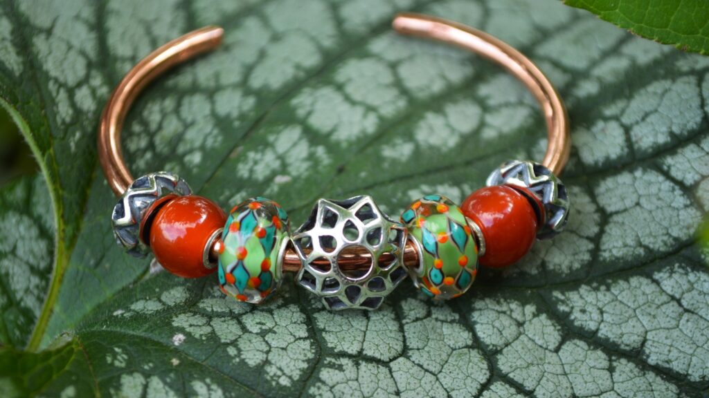 Trollbeads Autumn 2020 inspiration image featuring mandala themed silver beads on a copper trollbeads bangle